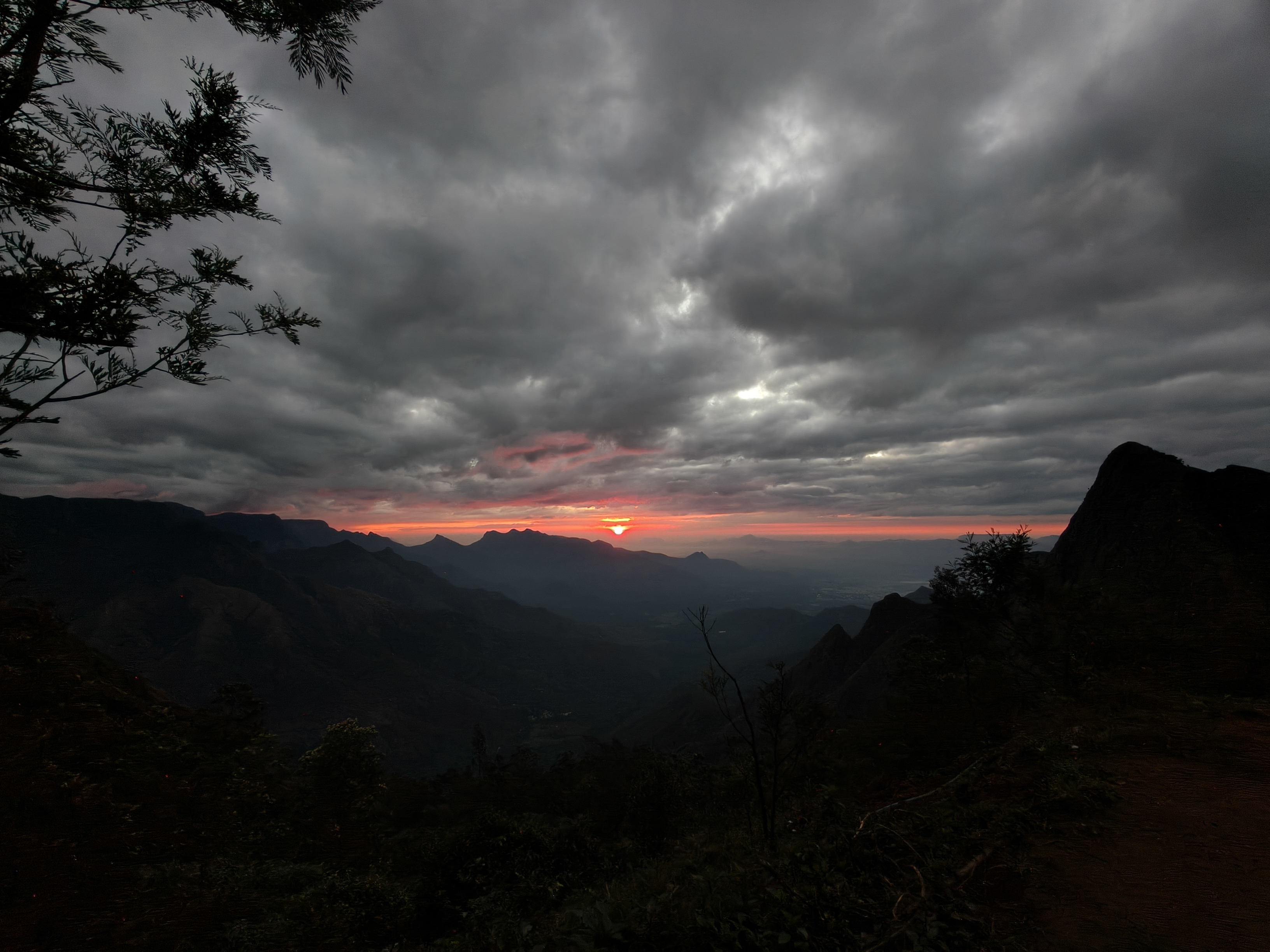 Kolukkumalai early dawn sky with soft orange horizon and dark mountain shadows